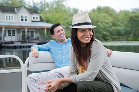 A woman and a man on a boat smiling and looking into the distance